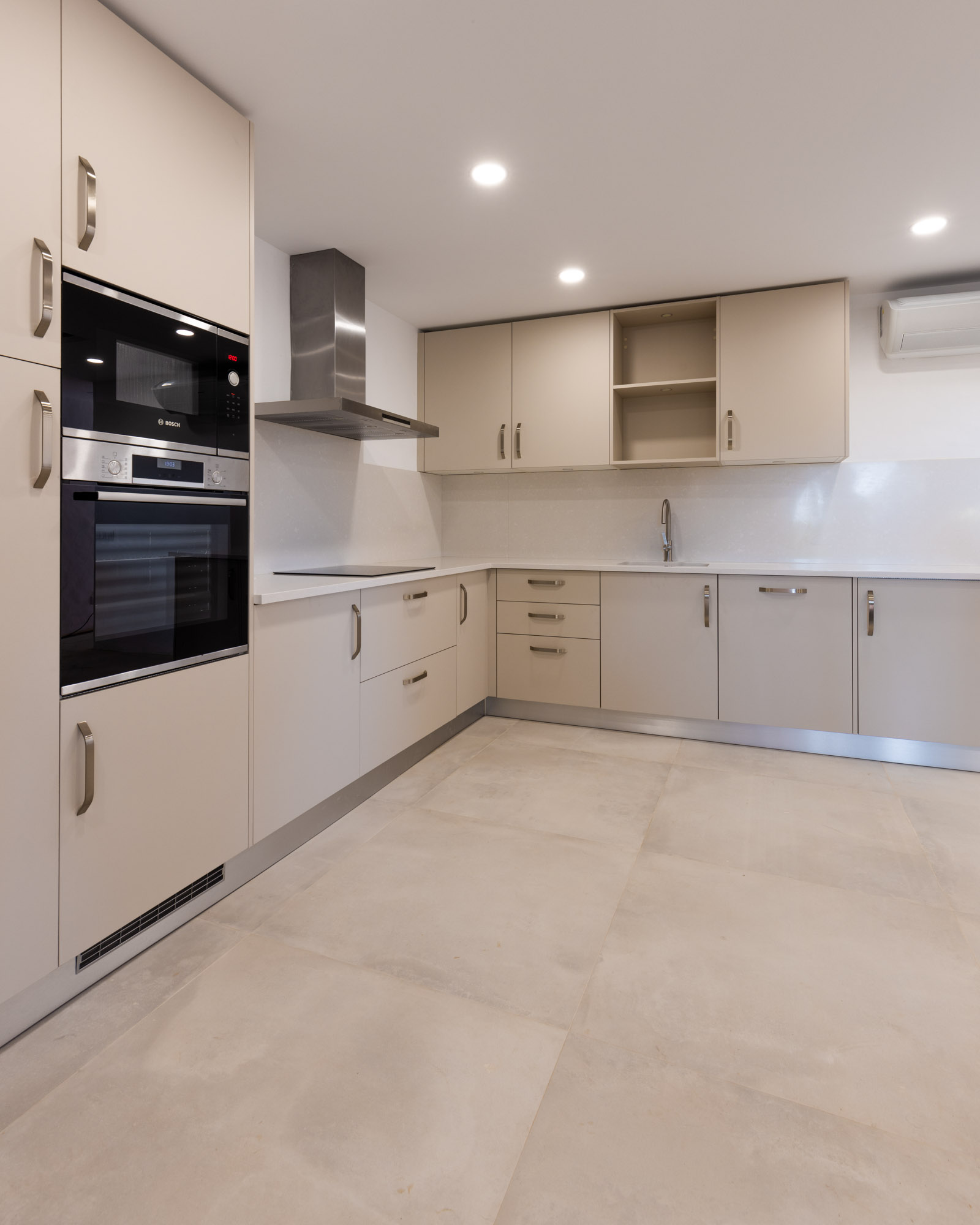 Ilha de cozinha moderna sem puxadores em lacado branco mate, com sistema de indução e exaustor BORA Classic