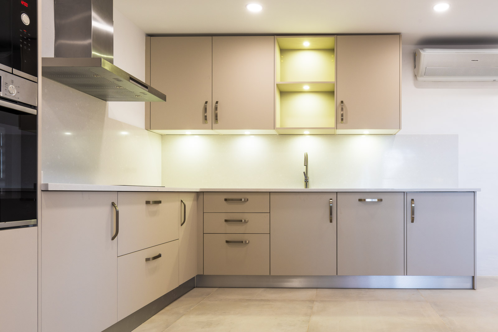 Ilha de cozinha moderna sem puxadores em lacado branco mate, com sistema de indução e exaustor BORA Classic