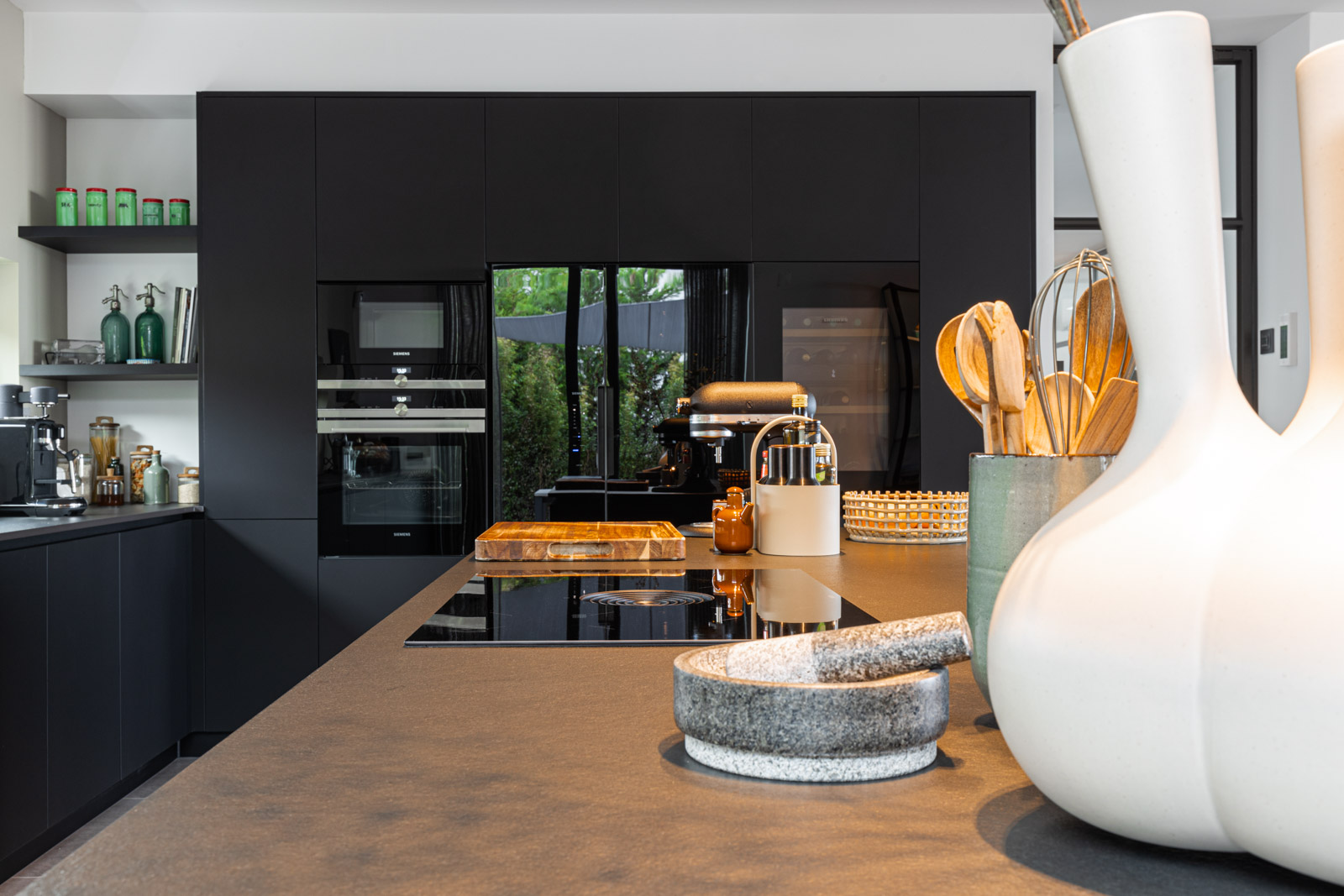 Cozinha luxuosa preta no Algarve Cozinha JMQ luxuosa no Algarve. Cozinha com frentes em Fenix preto, bancada em Neolith, sistema BORA Pure, garrafeira Liebherr e equipamentos Siemens.