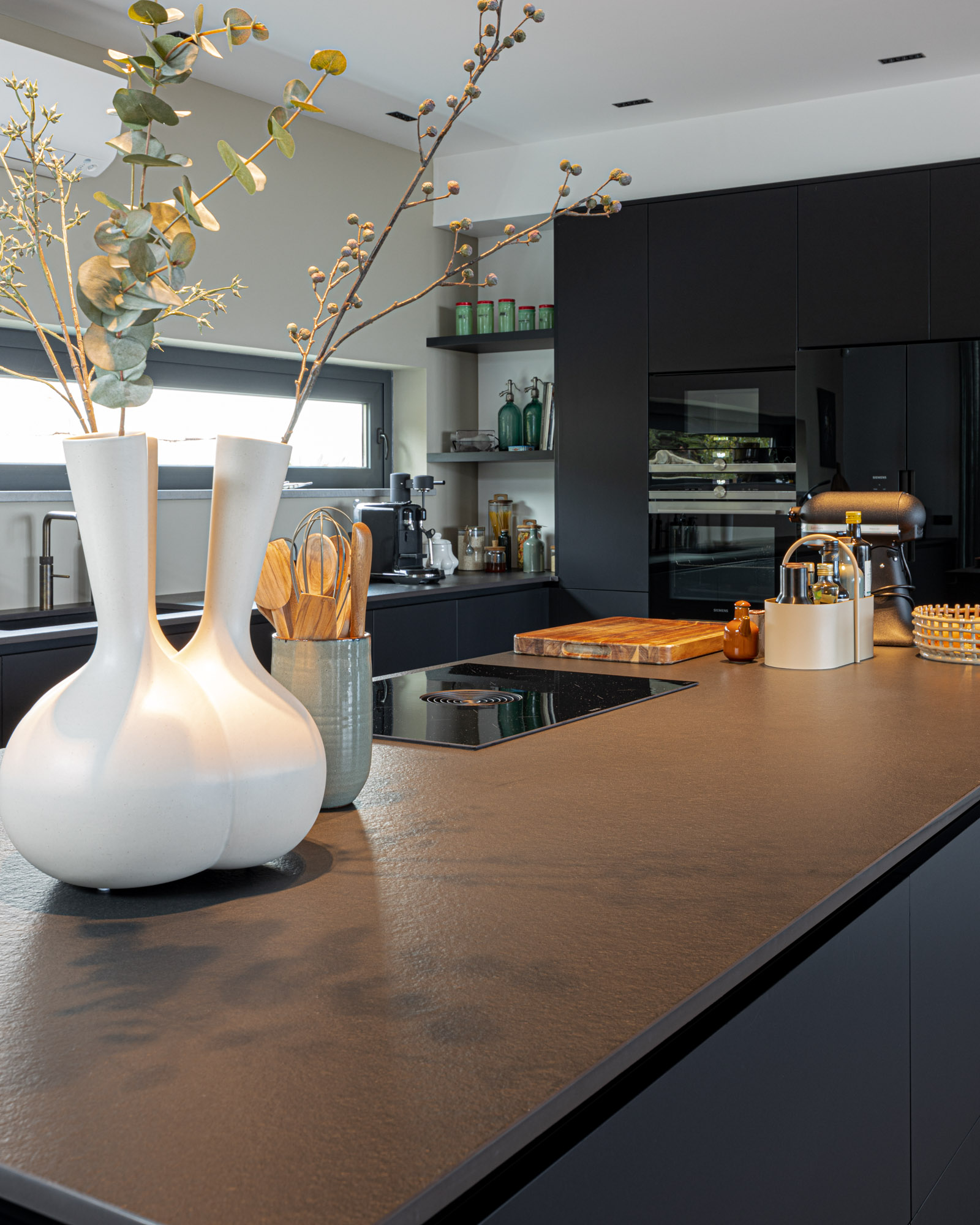 Cozinha luxuosa preta no Algarve Cozinha JMQ luxuosa no Algarve. Cozinha com frentes em Fenix preto, bancada em Neolith, sistema BORA Pure, garrafeira Liebherr e equipamentos Siemens.