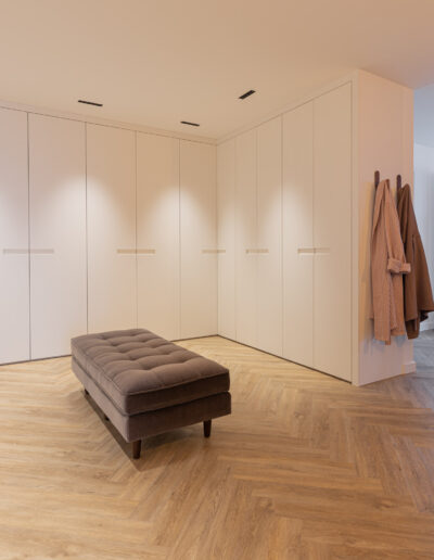 Luxuosa suite com roupeiro de canto com portas lacadas, com puxador incluído e divã.