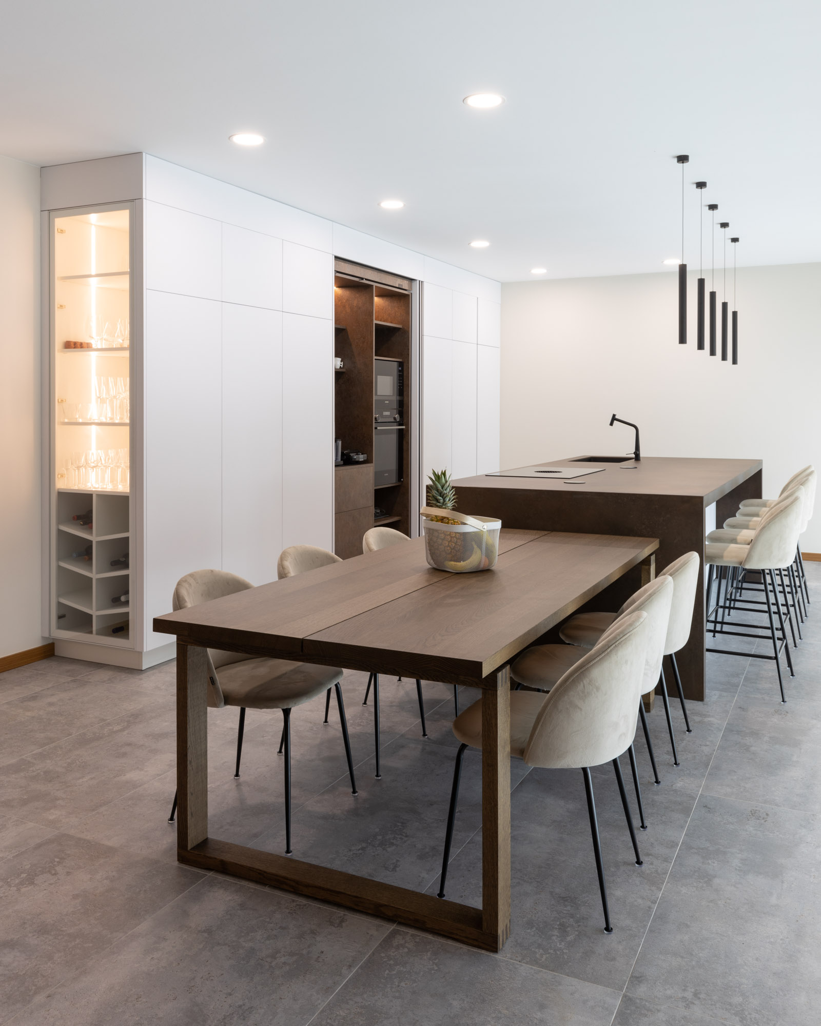 Cozinha branca com ilha Laminam em Portimão, Algarve Cozinha branca, com linhas contemporâneas e ilha com laterais em cascata, em Portimão. A cozinha conta com uma zona de pequenos-almoços com portas reentrantes.