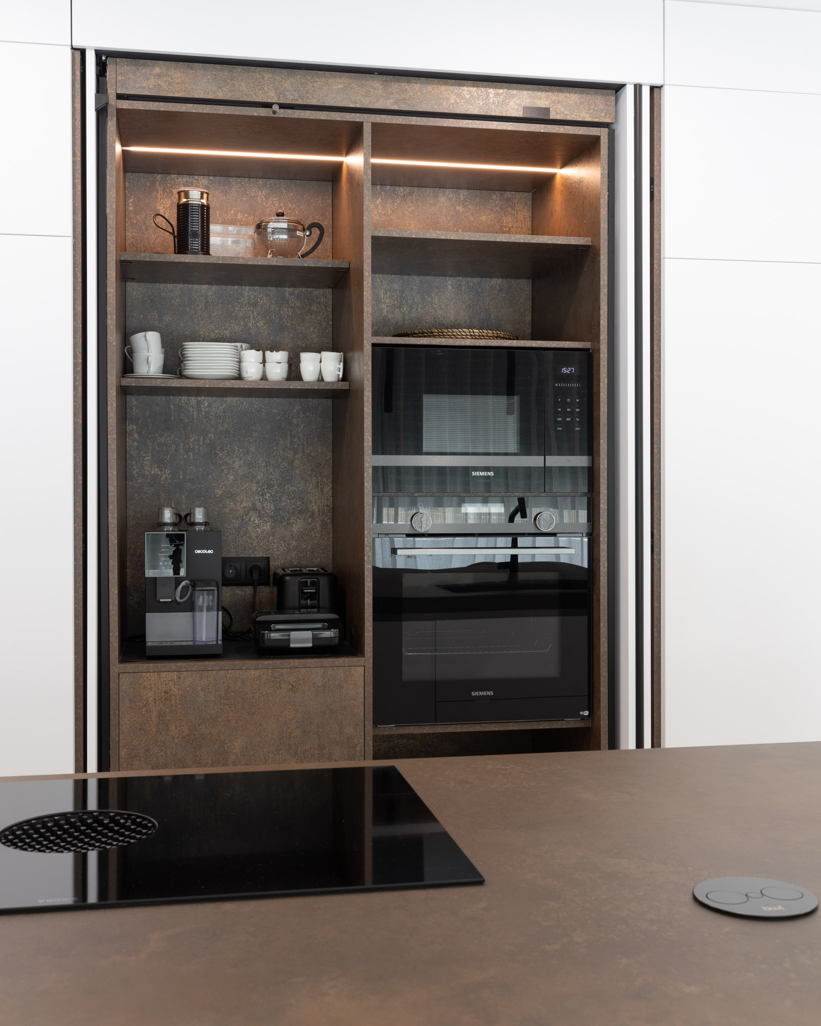 Cozinha branca com ilha Laminam em Portimão, Algarve Cozinha com zona de pequenos-almoços com portas reentrantes, que esconde também forno e micro-ondas.