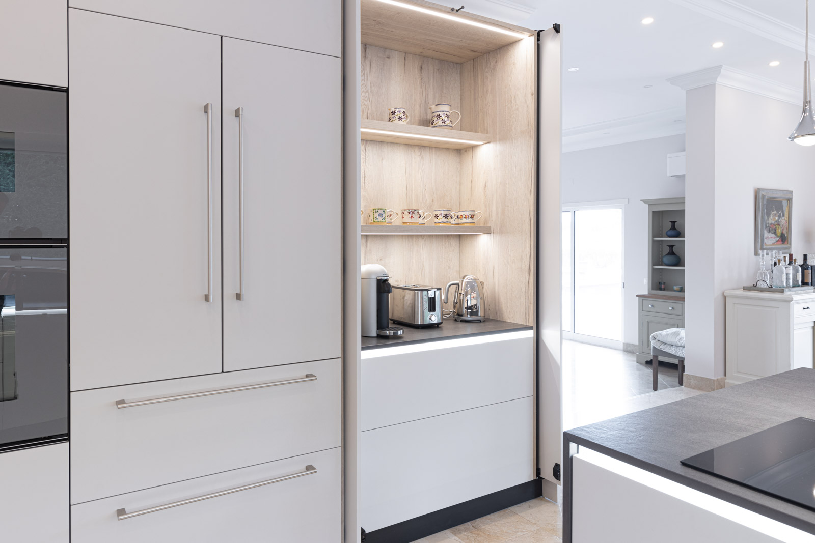 Cozinha JMQ de Luxo em Almancil, Algarve, com frentes lacadas em cinza suave mate. Incluí zona de pequenos-almoços com portas reentrantes.