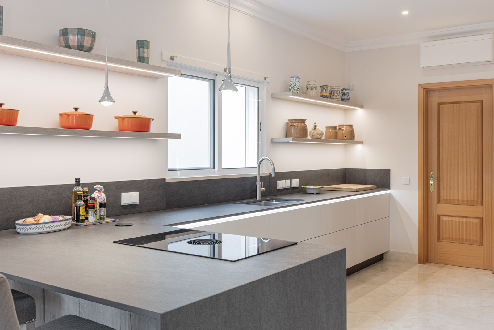 Cozinha JMQ de Luxo em Almancil, Algarve, com frentes lacadas em cinza suave mate, sistema BORA M Pure e bancada em Dekton Bromo.