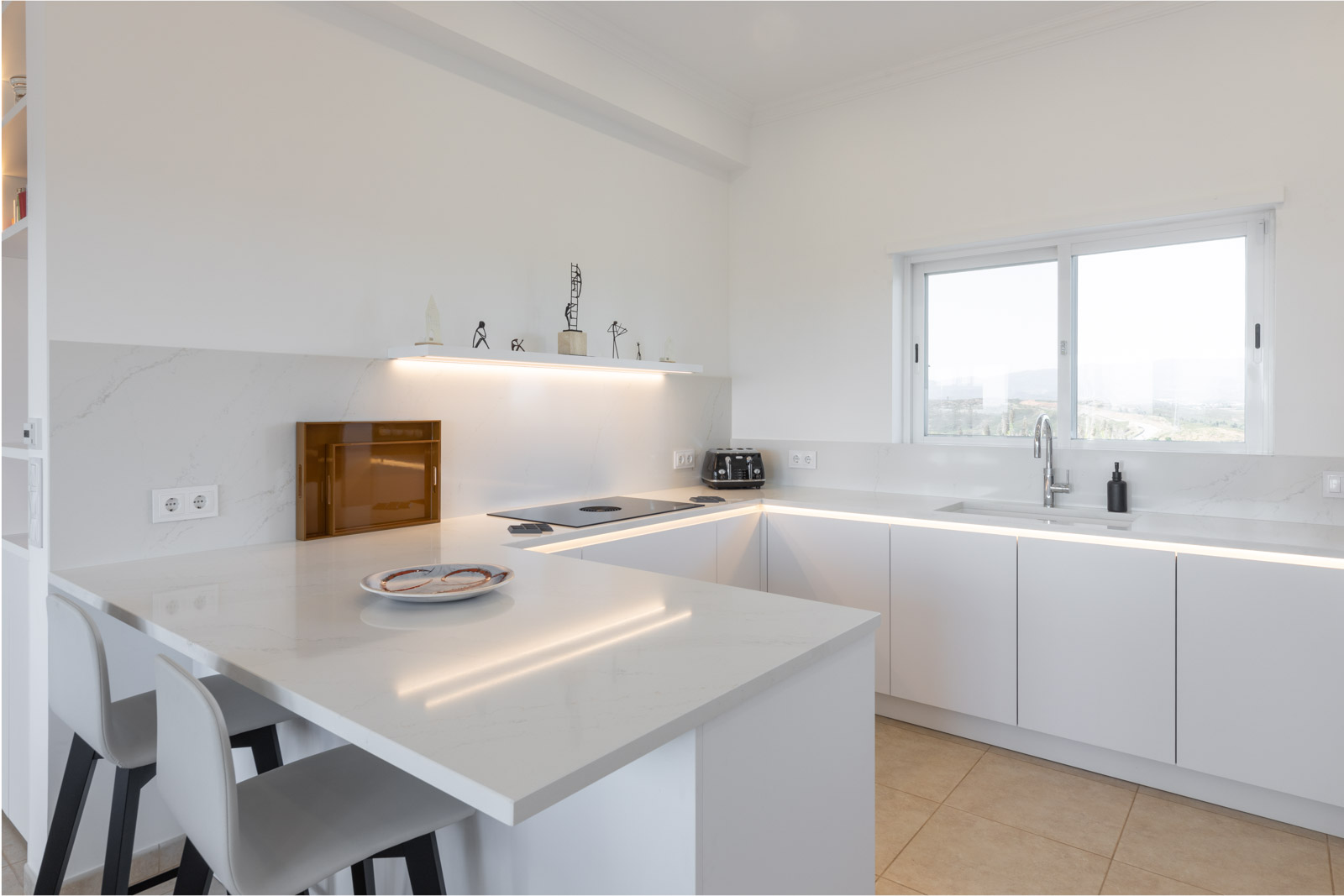 Cozinha branca com bancada Silestone Calacatta Gold, sistema BORA Pure e Quooker.